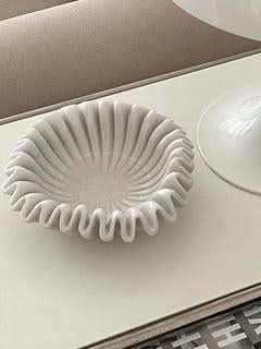 White fluted marble fruit bowl on a neutral surface, modern home decor accent.
